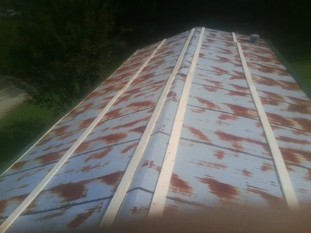 Rusted metal roof panels with new wood purlins before replacement — Storm Damage Roof Repair in Harrellsville by Roofing Brothers