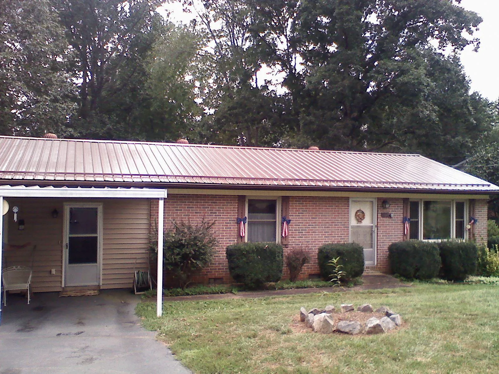 Bronze metal roof and carport on a brick ranch home — Roof Repair work by our crew in Harrellsville